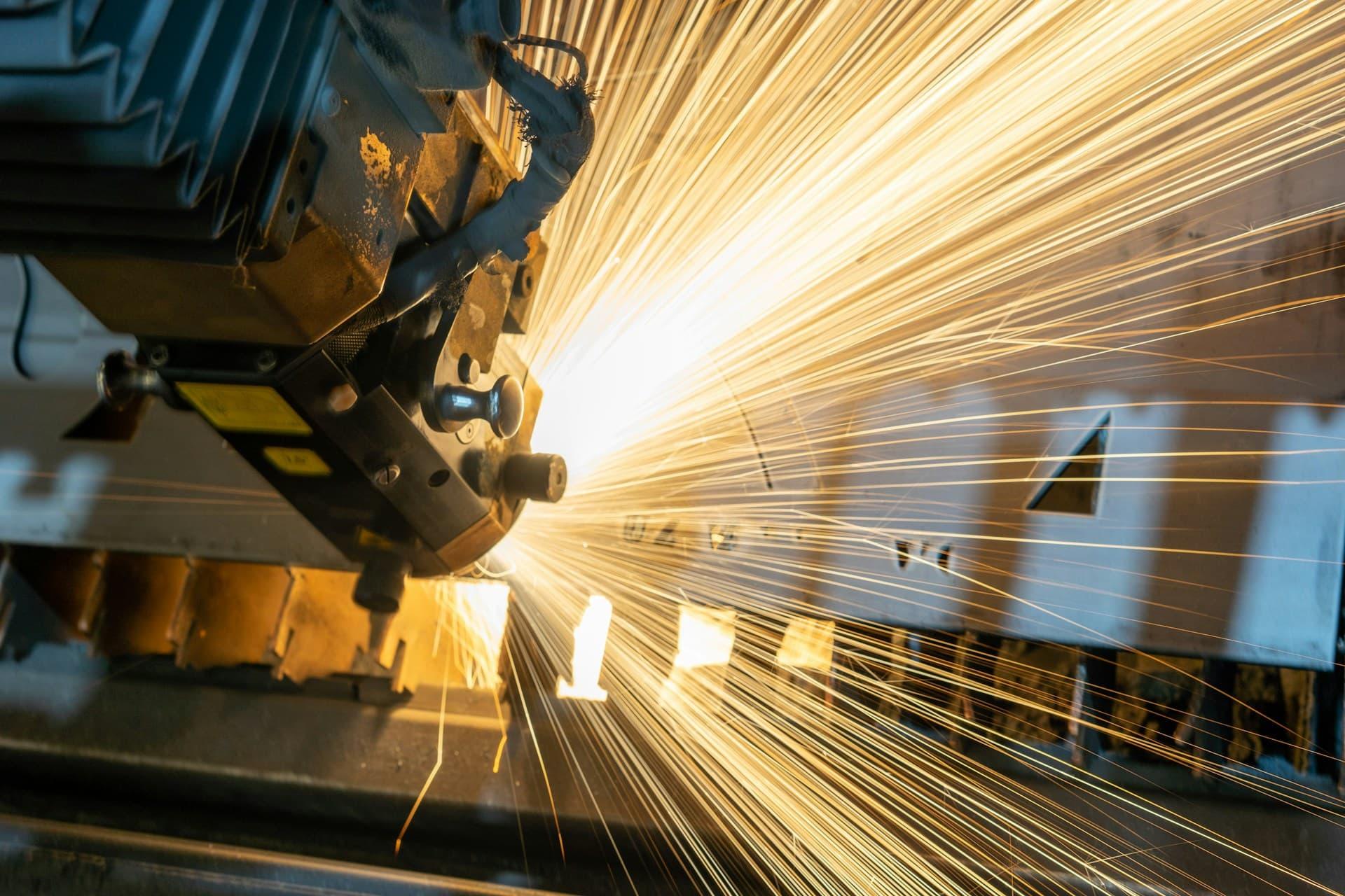 Industrial saw blade with sparks flying off of it.